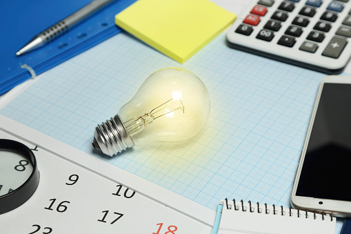 lit light bulb on desk, business concept