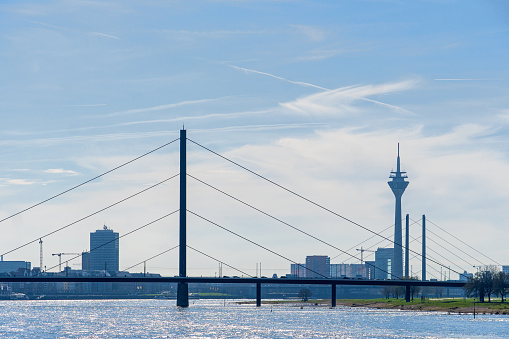 Düsseldorf, Germany, March 2024: Rhine River at Düsseldorf, with Rheinturm Tower and Oberkasseler Brücke