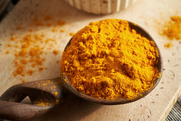 istock Turmeric root powder on a spoon on a wooden table 2084644887