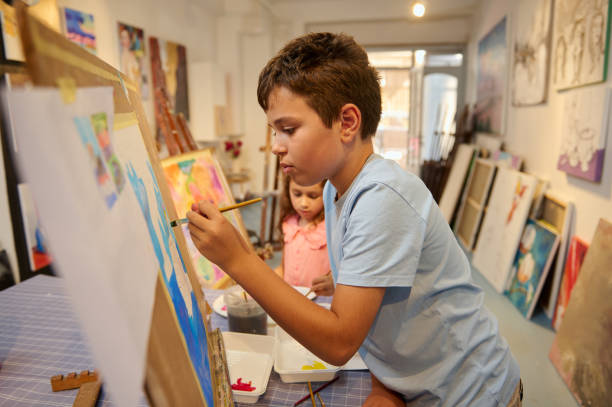 istock Talented elementary age kids, boy and girl during fine art, visual art class. Many pictures displayed in the art gallery 2084646450