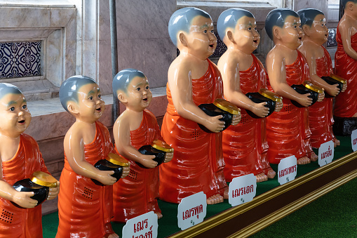 Line of Buddhist monk statues at Wat Rakhang (Temple of Bells) in Bangkok, thailand.