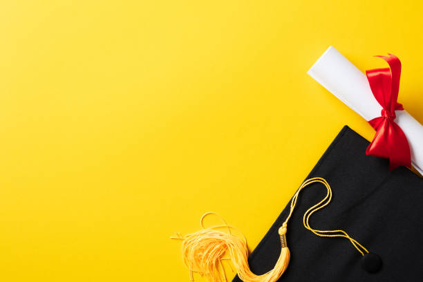 istock Graduation hat and diploma on yellow background. Flat lay, top view. 2084675575