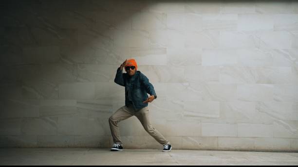 istock Motion shot of asian hipster perform break dance at gray background. Sprightly. 2084714638