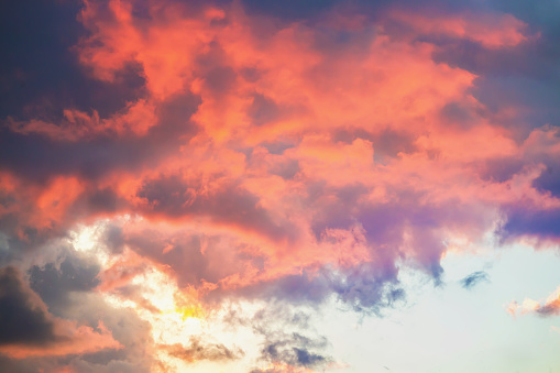 Fiery clouds dance across the sky at dusk, their vibrant hues painting a breathtaking canvas