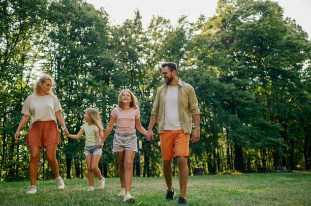 istock A happy family is walking in nature on meadow while holding hands. 2084812533