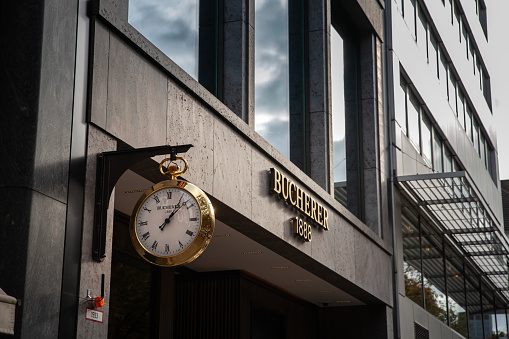 Dusseldorf, Germany - November 7, 2022: Picture of a sign with the logo of Bucherer on their Dusseldorf Shop. Bucherer Group is a multibrand watch and jewellery retailer based in Switzerland with over 100 stores worldwide. It was founded in 1888 by Carl F. Bucherer, who also became the namesake of a luxury Swiss watch brand. Bucherer retails brand including Rolex