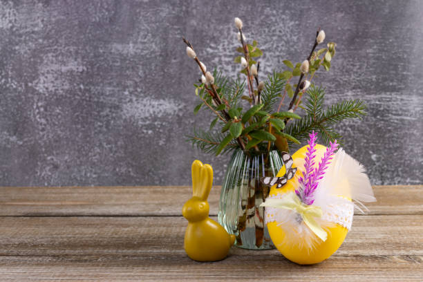 istock Wooden table with Easter bunny, egg and bunch of willow. 2084836164
