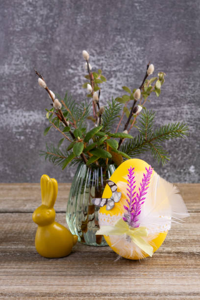 Wooden table with Easter bunny, egg and bunch of willow.