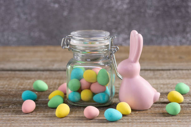 istock Easter composition with pink bunny and a jar with colorful candies. 2084836692