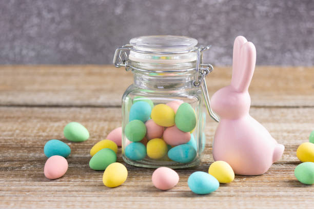 istock Easter composition with pink bunny and a jar with colorful candies. 2084837196