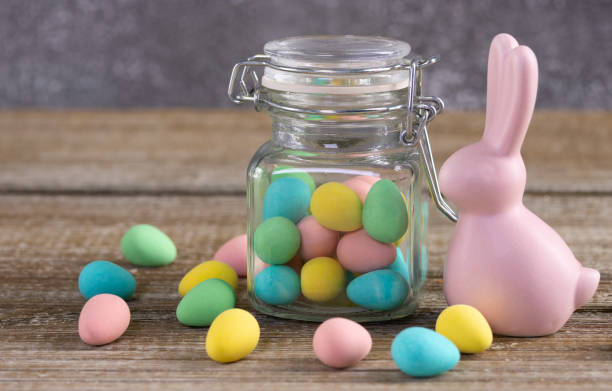 istock Easter composition with pink bunny and a jar with colorful candies. 2084837197