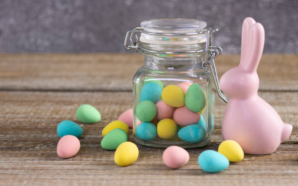 istock Easter composition with pink bunny and a jar with colorful candies. 2084837199