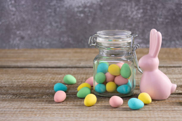 istock Easter composition with pink bunny and a jar with colorful candies. 2084837204