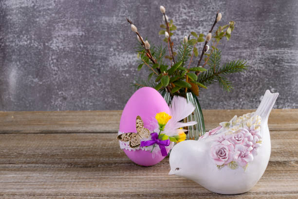 easter decorated egg, pussywillow and a figurine of bird on the table. - figurine easter egg easter holiday foto e immagini stock