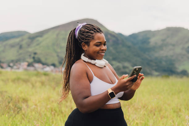 istock Plus size woman using smartphone on walk outdoors 2084881180