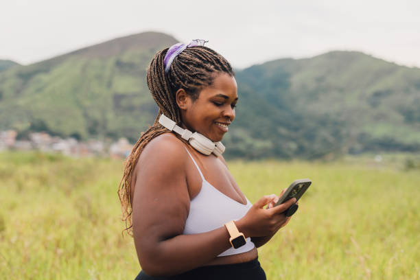 istock Plus size woman using smartphone on walk outdoors 2084881184