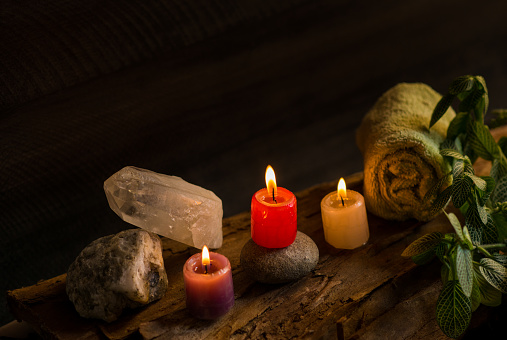 image of three coloured candles lit over an aromatherapy and relaxation area