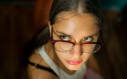close-up shot of a young woman wearing glasses while looking to the side