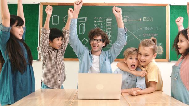 istock Teacher and student looking at laptop while celebrate success project. Pedagogy. 2084967155