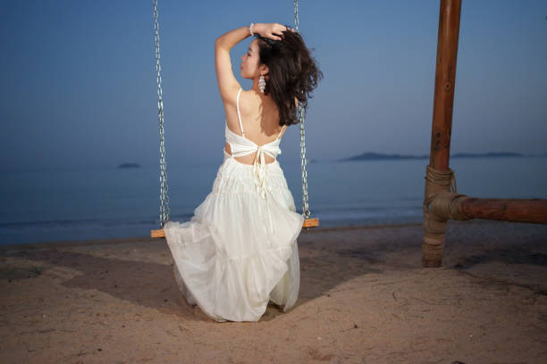 istock Asian woman sitting on swing 2084970485