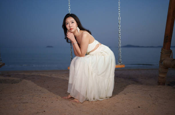 Asian woman sitting on swing