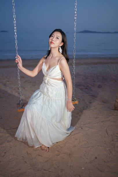 istock Beautiful woman sitting on swing 2084970493