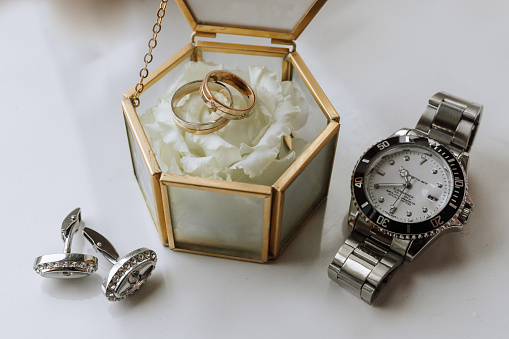 expensive men's watch. Cufflinks. Glass box with wedding rings. Details of the groom