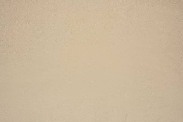 Part of a plain textured beige concrete wall.