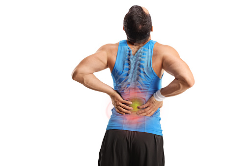 Rear view shot of a male athlete stretching his painful back with red inflamed spot and bone isolated on white background