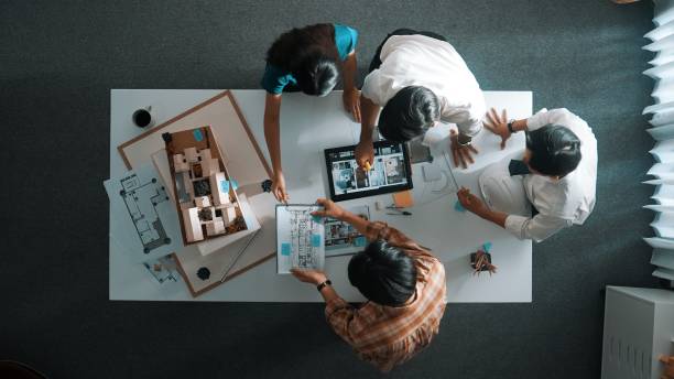 istock Top down view of architect team discussing and pointing at tablet. Alimentation. 2085010602
