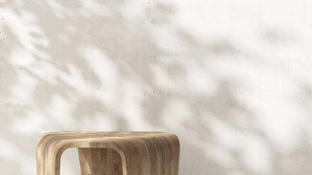 istock Geometric wooden pedestal table podium in dappled sunlight, leaf foliage shadow on white wall 2085013194