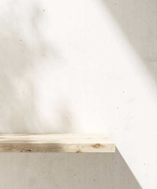 Brown natural wooden shelf in sunlight, tropical tree leaf shadow on white concrete wall