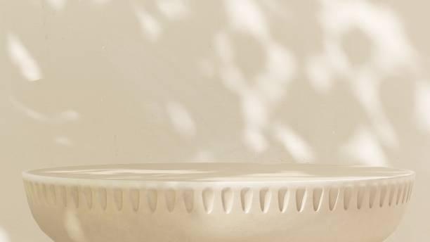istock Empty beige stone table podium in dappled sunlight, leaf foliage shadow on white cream concrete wall 2085044073