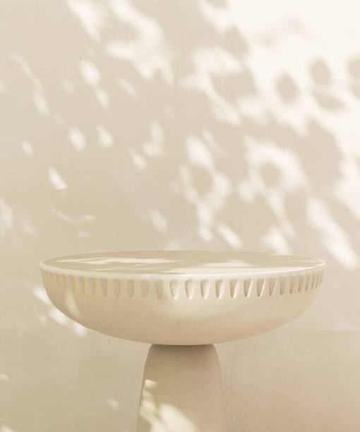 istock Empty beige stone table podium in dappled sunlight, leaf foliage shadow on white cream concrete wall 2085044074