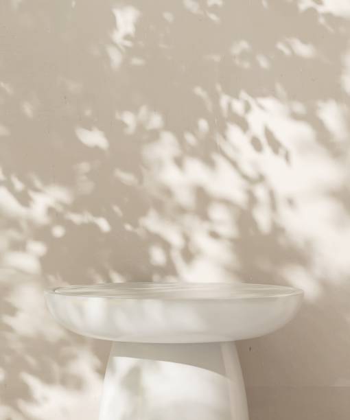 istock Minimal white stone podium in dappled sunlight, leaf foliage shadow on beige wall 2085044595