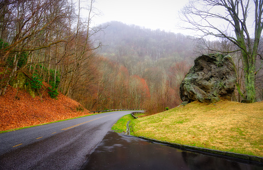 A colorful, rainy landscape on the Blue Ridge Parkway with a large boulder above the road in North Carolina, Eastern U.S.
