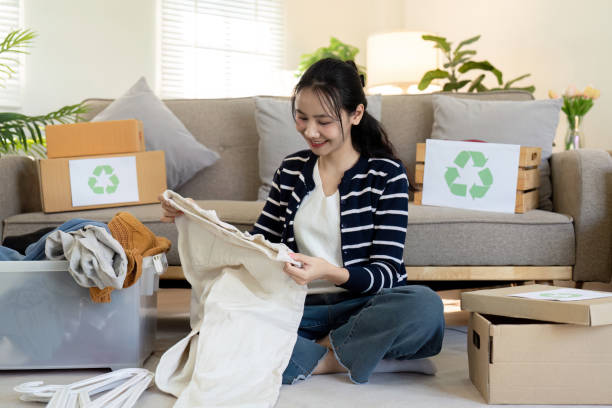 istock Woman pack box with used clothes for reuse. Reusing, recycling material and reducing waste in fashion, second hand apparel idea. Circular fashion, zero waste concept 2085104639