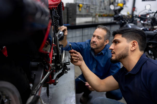 istock Team of mechanics fixing a motorcycle at a garage 2085107257