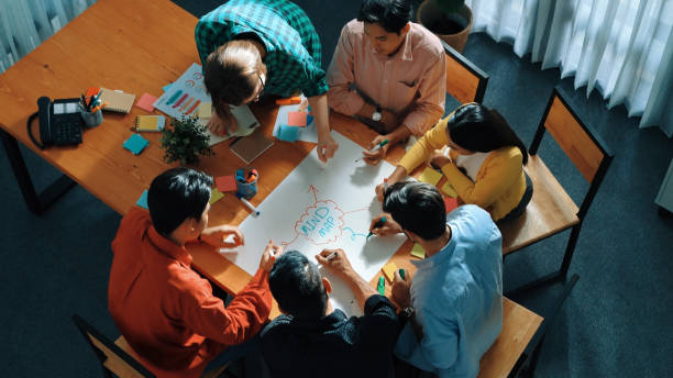 istock Top view of smart team brainstorming and writing mind map together. Convocation. 2085122494