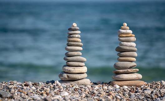 Balanced pebbles, isolated on white background with reflection