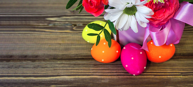 Easter chocolate eggs and sugar multicolored on pink background