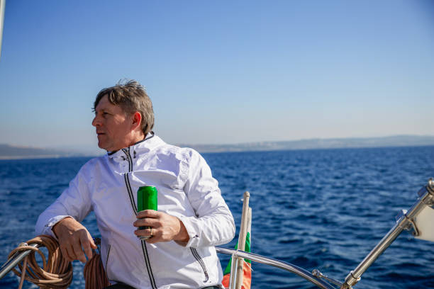 young man steers sailboat on sea - yacht nautical vessel autopilot sailing imagens e fotografias de stock