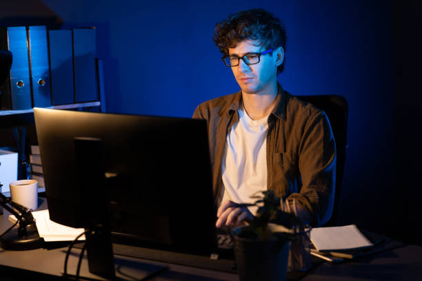 istock Businessman concentrating on pc on project at neon light office. Gusher. 2085293280