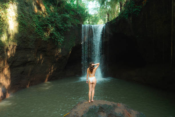 istock Woman enjoying refreshing waterfall on Bali island 2085305495