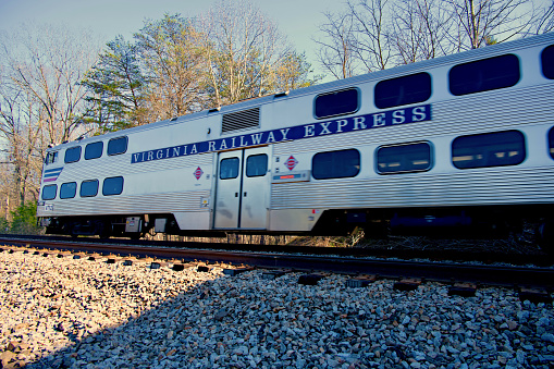 Fairfax Station, Virginia, USA - March 14, 2024: A Virginia Railway Express (VRE) commuter train travels West toward Manassas on a sunny afternoon.