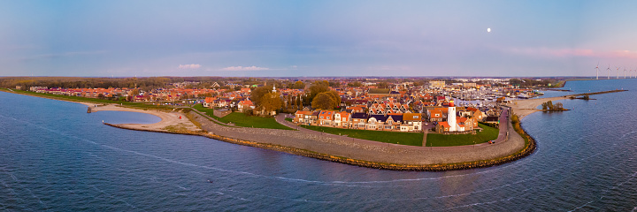 The Dutch village of Urk in Flevoland Netherlands with its old harbor and iconic lighthouse. panoramic drone aerial view
