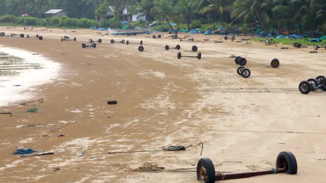 View of the beach used by local fishermen as a harborfor traditional fishing boats using car wheels on Sumenep beach, Madura island, Indonesia.