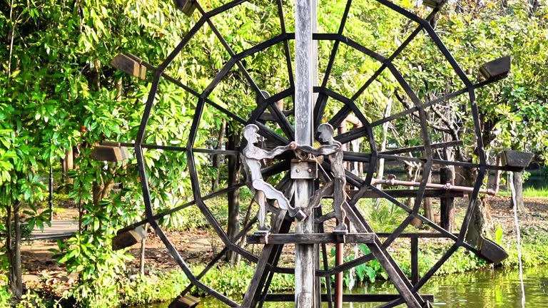 Video footage of a classic water turbine creating oxygen in a natural pond in a public park, Chiang Mai, Thailand.