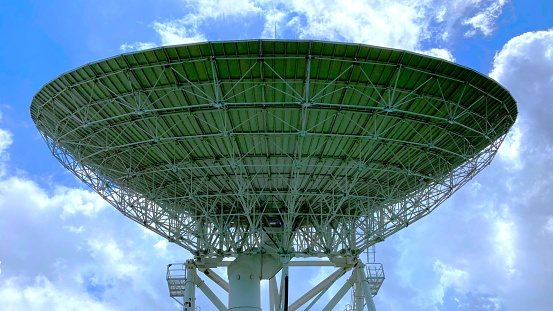 Large satellite dish with cloudy sky in Thailand, uplink and downlink transmission for broadcasting television program, voice and  data communications