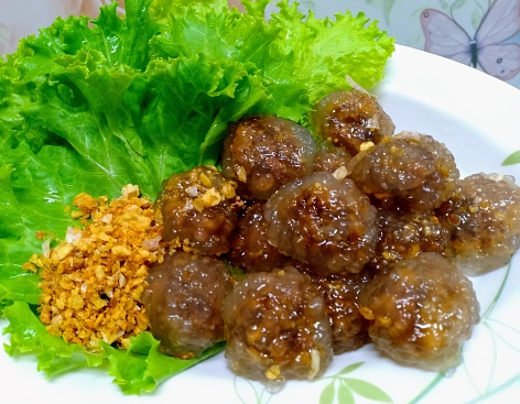 a photography of a plate of food with meatballs and lettuce.